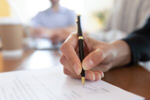 Business professionals reviewing and signing a franchise agreement to formalize their partnership.