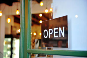 Open sign on a shop window with lights.