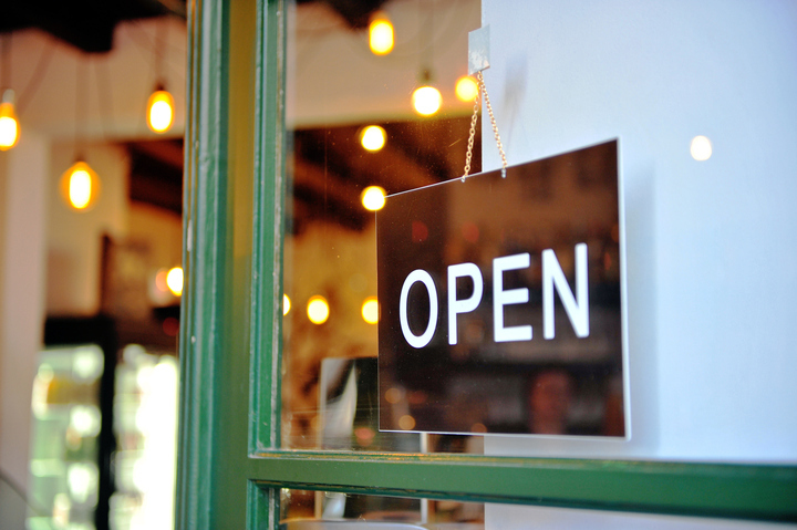 Open sign on a shop window with lights.