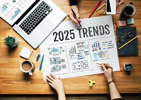People discussing 2025 trends with charts on table.