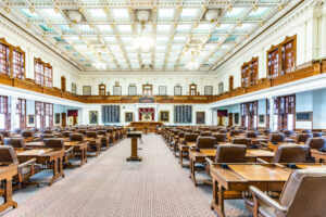 Empty legislative chamber with ornate design.