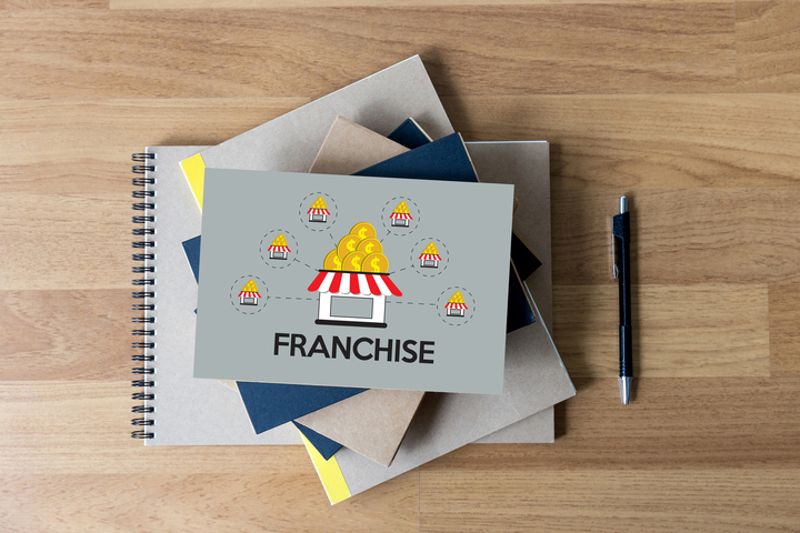 Franchise diagram on notebooks with pen on desk.