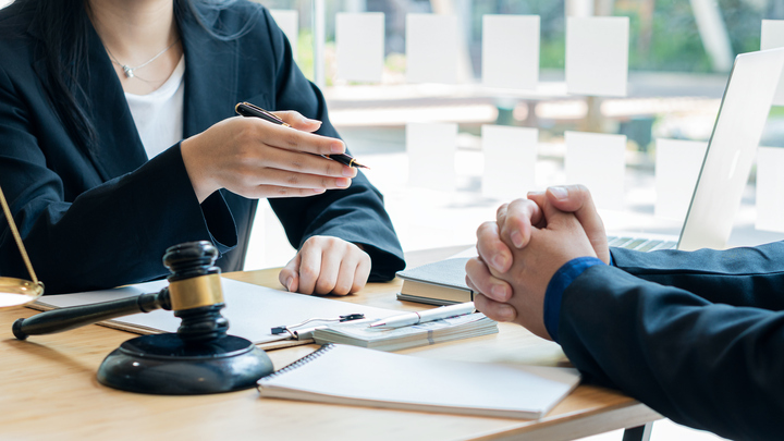 Lawyer consulting with client at office desk.