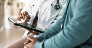 Doctor consulting patient using a tablet device.