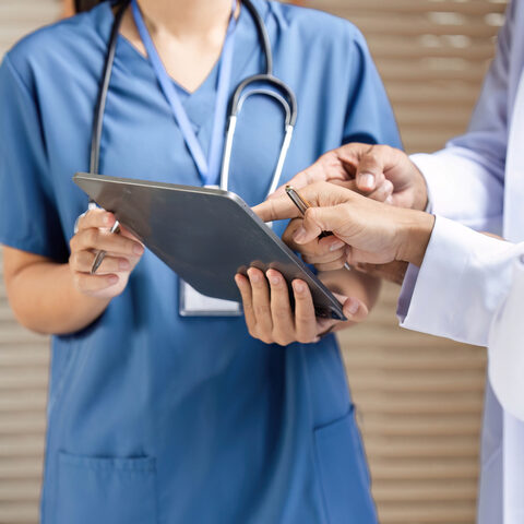 Doctors reviewing patient information on tablet