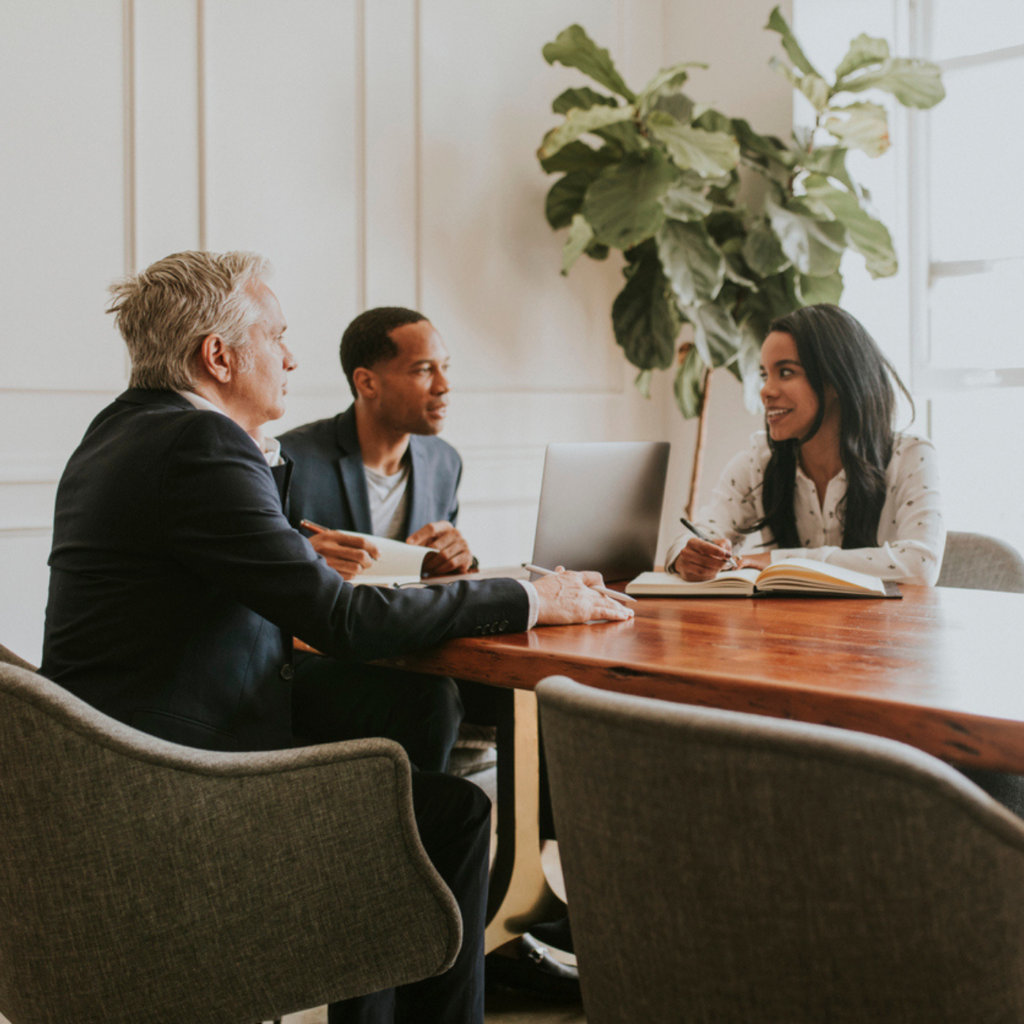 Three professionals meeting at office conference table
